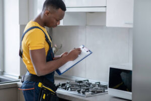 A man inspecting a gas stove in a home.